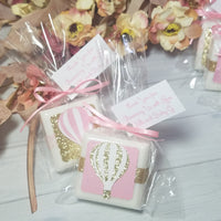 Baby shower favor soaps with hot air balloons paper piecing design on the front pink and gold they are tied with ribbons and text on a hanging tag that can be customized