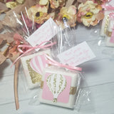 Baby shower favor soaps with hot air balloons paper piecing design on the front pink and gold they are tied with ribbons and text on a hanging tag that can be customized