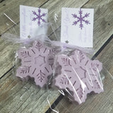 Purple colored snowflake soaps ready to hand out as favors with customized text on hang tags tied with ribbon