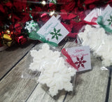 white snowflake soap favors wrapped with green and red ribbon and tagged  with personalized lettering, themed for a Christmas event