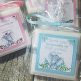 White baby shower soap favors with a blue and pink version of elephants and personalized wording