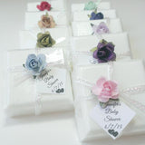 white soap wedding favors, wrapped with a ribbon and topped with a single mulberry paper flower multiple choices in the picture