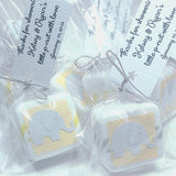 All white baby shower soap favors with yellow and grey accents elephant cutouts ion front and tied with twine includes a personalized hanging tag